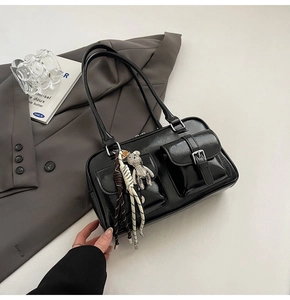 Minimalist black bowling shoulder bag in glossy faux leather with outer pockets