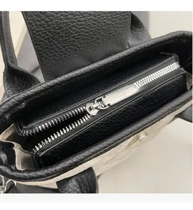 Close-up of smooth silver zipper and litchi grain leather on the bucket bag