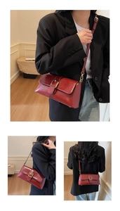 Détail du sac baguette rouge foncé avec boucle dorée et texture en cuir brillant