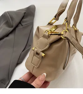 Detailed close-up of premium gold hardware on a vintage cream shoulder bag
