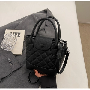 Close-up of black lychee grain leather bucket bag with classic diamond stitching detail
