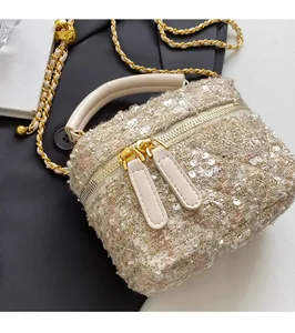 Detailed top view of a tweed box bag featuring pink sequins and gold chain strap