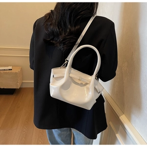 Vista dettagliata del retro di una borsa tote bianca in vernice lucida con manici