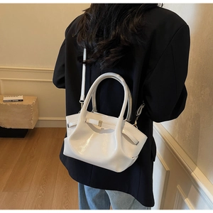 Vista dettagliata della borsa tote in pelle verniciata bianca con design plissettato e fibbie