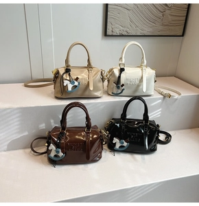 Detail view of four Boston bags in glossy patent leather with debossed brand lettering