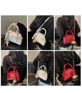 Model display of white and burgundy bowling bags with baseball charms and strap details