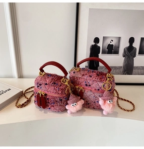 Detailed view of pink tweed box bag with gold chain and plush monster charm decoration