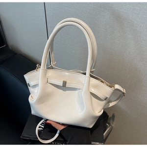 Dettaglio borsa tote in pelle verniciata bianca con fibbia in metallo e pieghe