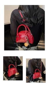 Detail of red vintage bowling bag featuring leather texture and baseball charm accessory