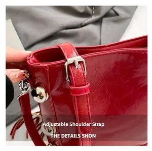 Detail of red PU leather bucket bag with silver studs and adjustable shoulder strap