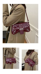 Close-up of wine red patent leather shoulder bag with silver studs and punk metal buckles
