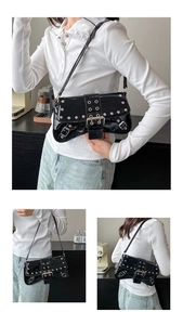 Detail of black glossy punk underarm bag featuring silver eyelets and buckle accents