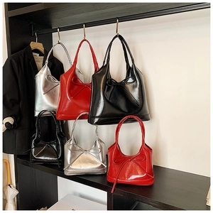 Detail of high-gloss bow tote bags in black, red, and silver finishes for women