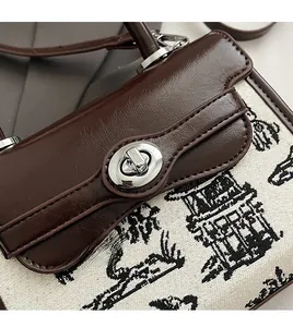 Detail of premium silver rotary lock on brown leather and printed canvas bag