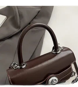 Detail of vintage brown oil wax leather handle and silver lock on a chic handbag
