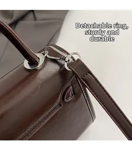Detail of silver detachable ring and durable strap hook on dark brown crossbody bag