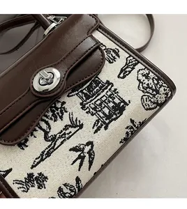 Close-up of vintage floral jacquard fabric with dark brown leather trim and silver metal lock