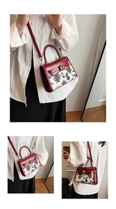 Detail of red jacquard handbag showing floral rabbit pattern and metal twist lock