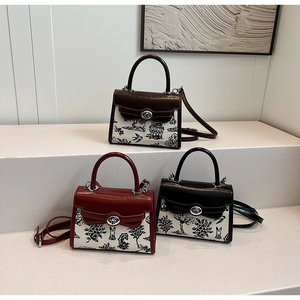 Detail of vintage canvas satchels with artistic landscape prints and leather handles