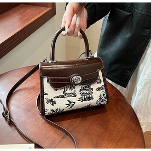 Macro shot of retro canvas handbag with mountain landscape print and silver metal lock