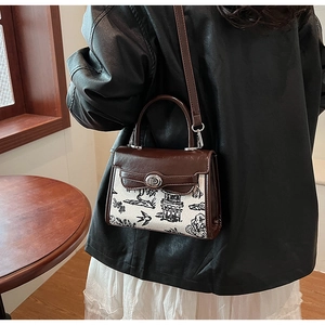 Detail of vintage crossbody bag showing contrast stitching and metal twist-lock closure