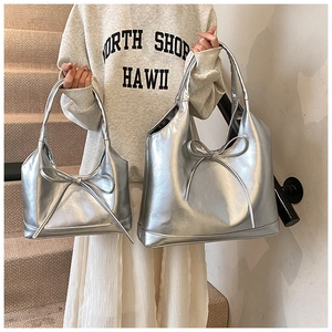 Comparison of two sizes for silver metallic tote bags with bow detailing and oily texture