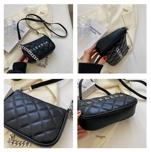 Detail of black quilted shoulder bag featuring silver metal letters and chunky chain strap