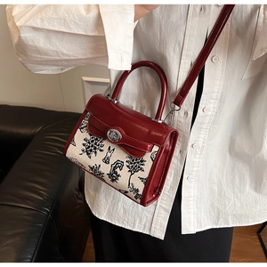 Close-up of red leather and canvas Kelly bag featuring rabbit prints and silver clasp