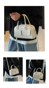 Creamy white glossy oil-wax leather Boston bag shown in crossbody and handheld styles