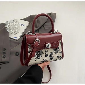 Detail of burgundy and cream leather canvas bag with rabbit print and metal twist lock