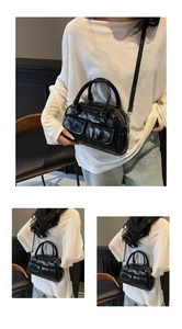 Detail view of black oily leather Boston bag with dual pockets and crossbody strap