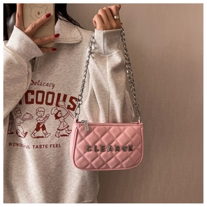 Detailed shot of pink quilted PU leather bag with silver chunky chain and metal logo