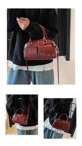 Detail view of burgundy oil wax leather Boston bag showing pockets and silver hardware