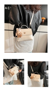 Detail of cream PU leather handbag featuring a rotating metal clasp and plush bear charm