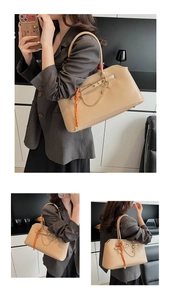 Detail of beige large tote bag with gold chain and silk scarf on a stylish shoulder bag