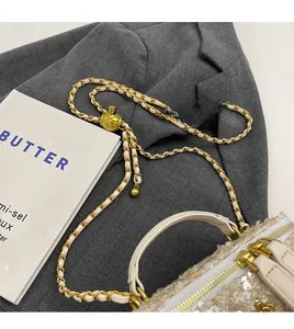 Detail of adjustable gold ball buckle and tweed chain strap on elegant box handbag