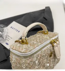 Close-up of beige tweed chain bag with gold sequins and a metallic top handle detail