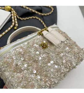 Detailed shot of beige tweed texture with sequins and golden camellia hardware