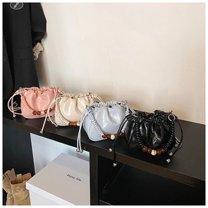 Detail of quilted cloud bucket bags with braided handles and amber bead accents