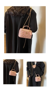 Detailed view of pink tweed vanity bag with gold flower accent and chain strap