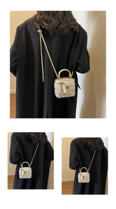Detail of white sequin tweed mini bag with gold flower badge and chain strap