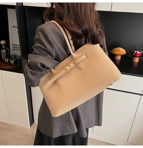 Dettaglio della grande borsa a spalla beige con fibbia dorata e cuciture di qualità