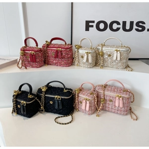 Detail of tweed vanity bags in four colors with chain straps and camellia buckles
