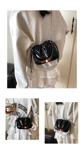 Detail of black glossy pleated bucket bag with decorative brown and white beads