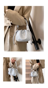 Detail view of light blue bucket bag featuring diamond quilted stitching and woven handle