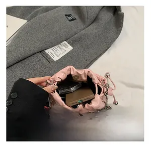 Detail view of the pink drawstring bucket bag showing internal capacity and metal chain
