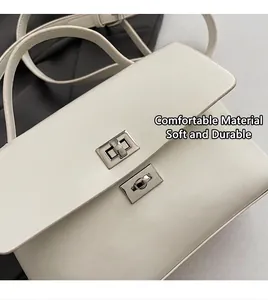 Detailed close-up of ivory messenger bag featuring dual silver metal turn-lock closures