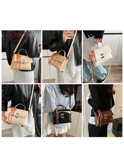 Close-up of stylish faux leather handbags with silver square locks and orange charms