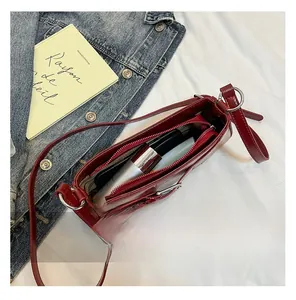 Detail showing inner capacity of dark red faux leather shoulder bag with essentials