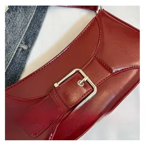 Close-up of wine red leather bag texture with oversized silver square buckle detail